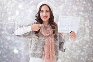 Composite image of brunette in winter clothes showing sale sign