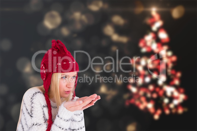 Composite image of festive blonde blowing over hands