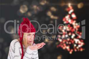 Composite image of festive blonde blowing over hands