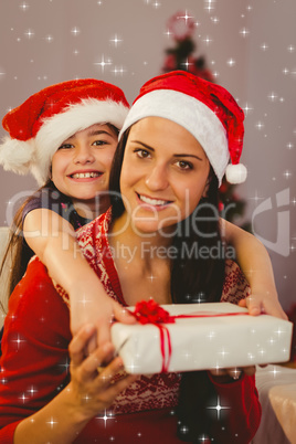 Composite image of festive mother and daughter smiling at camera