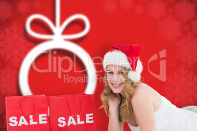 Composite image of festive blonde with sale shopping bags and pr