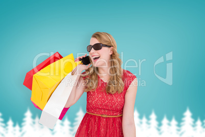 Composite image of pretty blonde talking on phone holding shoppi