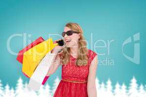 Composite image of pretty blonde talking on phone holding shoppi