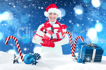 Composite image of festive woman holding gifts