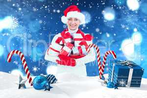 Composite image of festive woman holding gifts