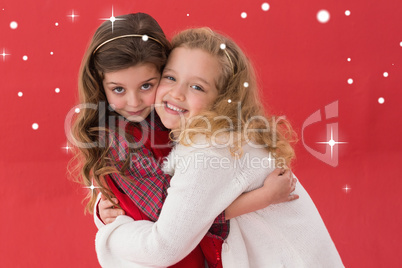 Composite image of festive little girls hugging and smiling