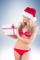 Festive fit blonde in red bikini showing gift