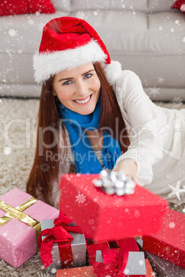 Composite image of festive redhead smiling at camera with gifts