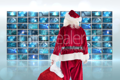 Composite image of santa carrying sack of gifts