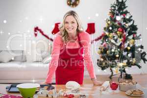 Composite image of festive blonde making christmas cookies