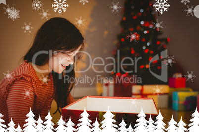 Composite image of little girl opening a glowing christmas gift