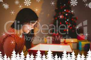 Composite image of little girl opening a glowing christmas gift