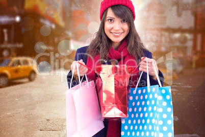 Composite image of smiling brunette opening gift bag