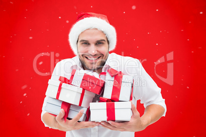 Composite image of festive man holding christmas gifts