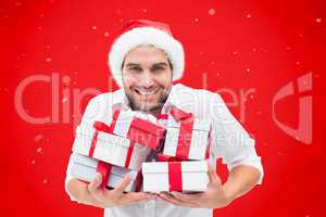 Composite image of festive man holding christmas gifts