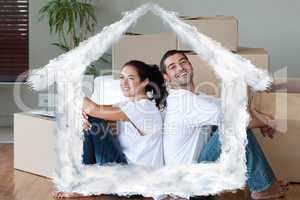 Composite image of bright couple with unpacking boxes moving to