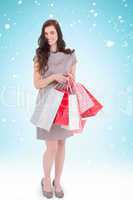 Composite image of elegant and smiling brunette with shopping ba