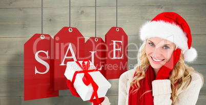 Composite image of happy festive blonde with gift