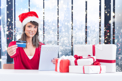 Composite image of festive brunette shopping online with tablet