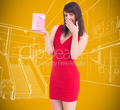 Composite image of festive brunette holding a gift bag