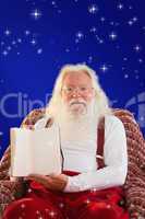 Composite image of father christmas showing a book