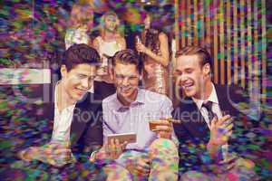 Composite image of handsome friends having a drink together