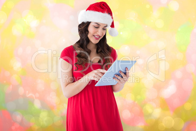 Composite image of festive brunette using her tablet pc
