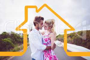 Composite image of cute couple standing on the road hugging