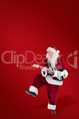 Composite image of santa claus has fun with a guitar