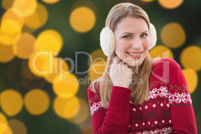 Composite image of woman wearing warm ear muffs