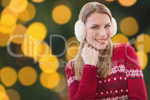 Composite image of woman wearing warm ear muffs
