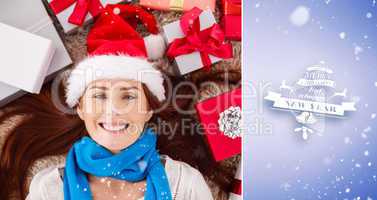 Composite image of festive redhead smiling at camera with gifts