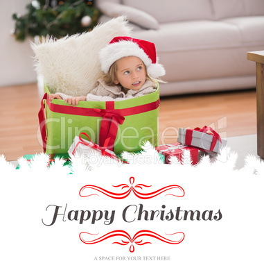 Composite image of cute little girl sitting in giant christmas g