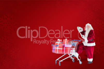 Composite image of santa pushes a shopping cart while reading