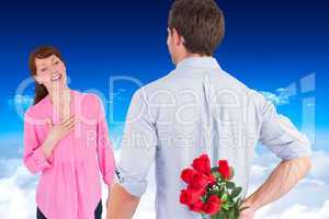 Composite image of man holding roses behind him