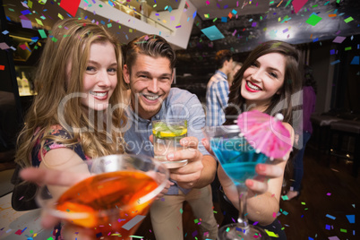 Composite image of happy friends having a drink together