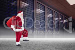 Composite image of santa carrying sack of gifts