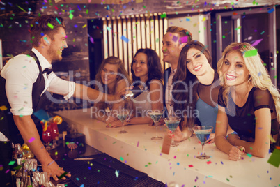 Composite image of attractive friends being served cocktails