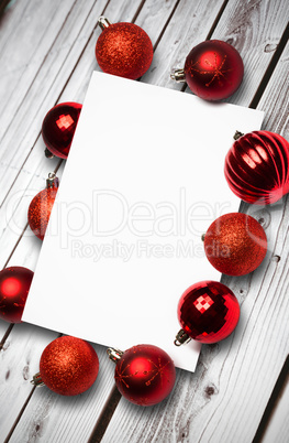 Composite image of red christmas baubles surrounding white page Composite image of red christmas baubles surrounding white page