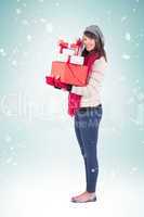 Composite image of pretty woman holding pile of gifts
