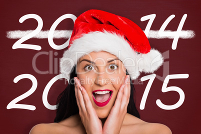 Composite image of surprised woman wearing santa hat