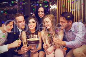 Composite image of attractive friends celebrating a birthday