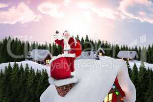 Composite image of santa on cottage roof