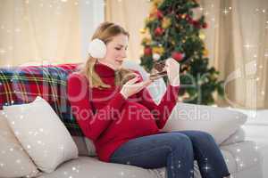 Composite image of pregnant woman looking at baby shoes sitting