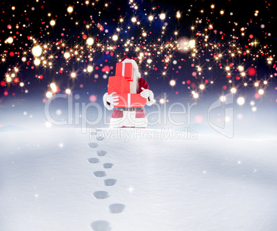 Composite image of santa carrying gifts in the snow