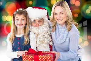 Composite image of mother and daughter with santa claus