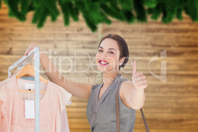 Composite image of smiling woman giving thumbs up