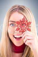 Happy blonde holding red snowflake