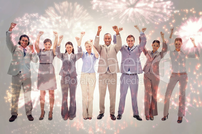 Composite image of happy business team raising their arms