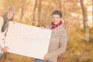 Composite image of young couple holding a poster